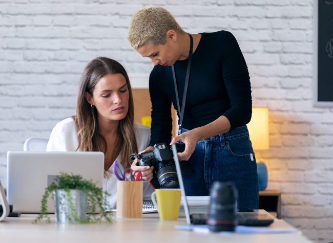 Shot of modern entrepreneur women reviewing last photographs in the camera for they next work in the office.